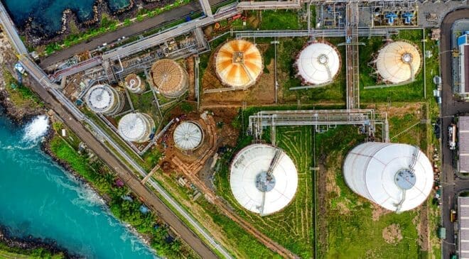 Aerial view of an industrial complex near a river in Banten, Indonesia, showcasing storage tanks.