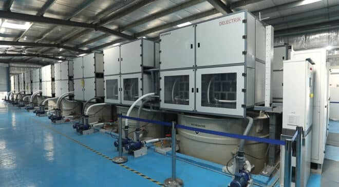vanadium flow battery tanks beside solar panels at a Gujarat utility-scale site, 100 mwh liquid