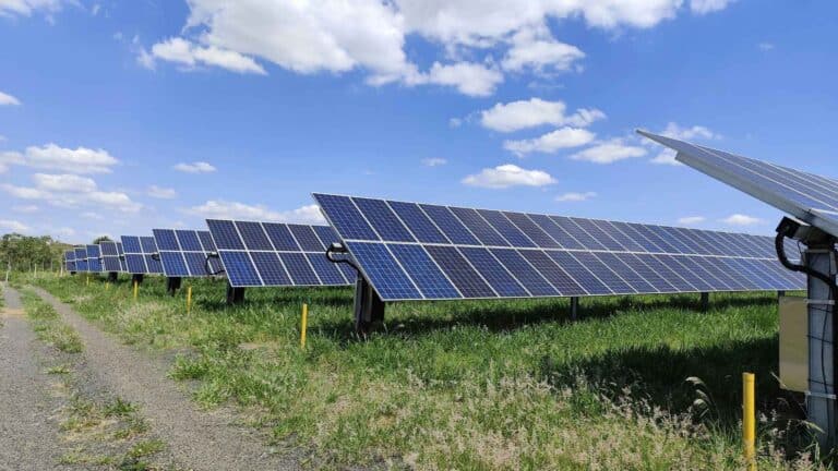 A vertical bifacial rows of a solar fence running beside airport grass