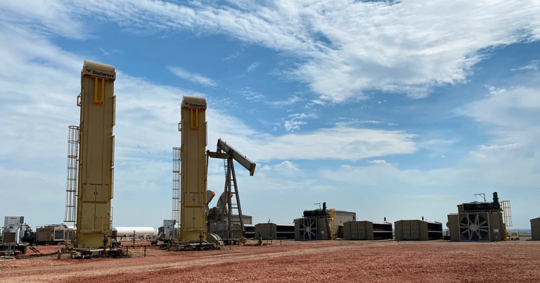 At a Bakken oil pad in North Dakota, gas once burned off in a flare feeds 86 mobile data centers, and the stack that used to light up the dark stands unlit 4 Shipping container computers run on flare gas beside a dark oil well flare stack, bakken oil pad